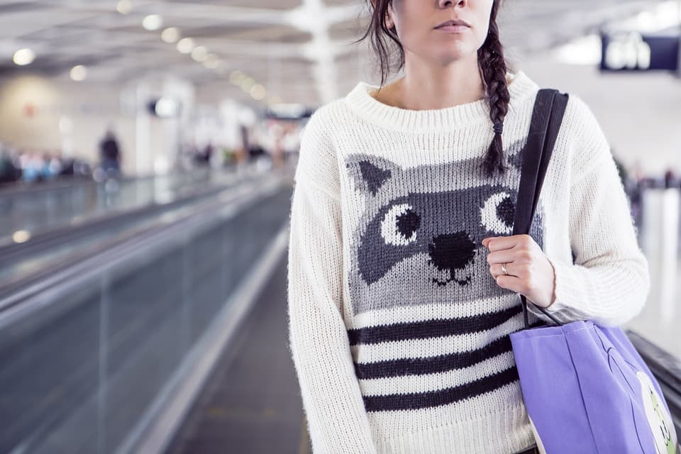 Reisende mit Handgepäck auf dem Laufband im Terminal